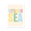 A colourful typography art print with the text 'VITAMIN SEA' in various hues of pink, green, blue, and yellow on a pale sandy background.