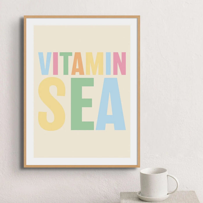 Framed colourful typography art print with the words 'VITAMIN SEA' in multicoloured letters on a beige background.
