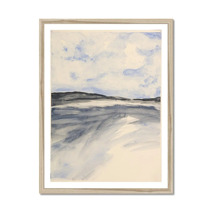 A framed watercolour painting depicting a coastal landscape with blue sky and clouds over a misty bay, set in a wooden frame.