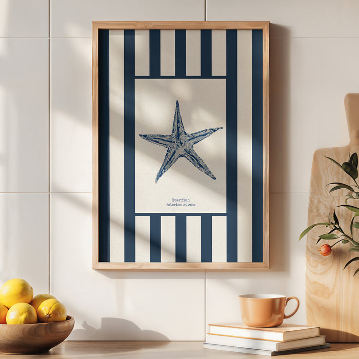 Framed artwork of a blue starfish on a white background with blue stripes, displayed on a wall above a table with books and a cup.