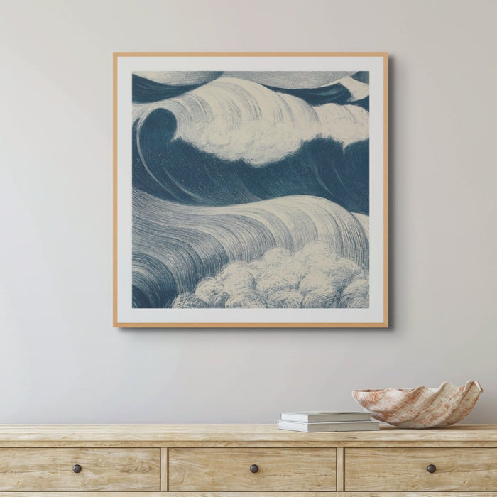 Wave art print - blue sea painting with a black frame on a white painted wall above a wooden sideboard.
