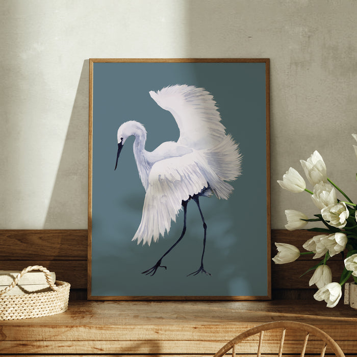 Framed artwork of a white bird on a blue background, displayed on a wooden surface with flowers.