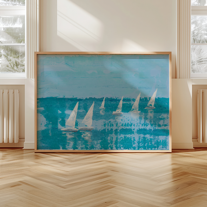 Framed artwork of sailboats on a blue background in a room with large windows.